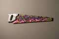 An antique hand saw with a graffiti adorned blade with the words ‘guidance’ painted in colourful lettering