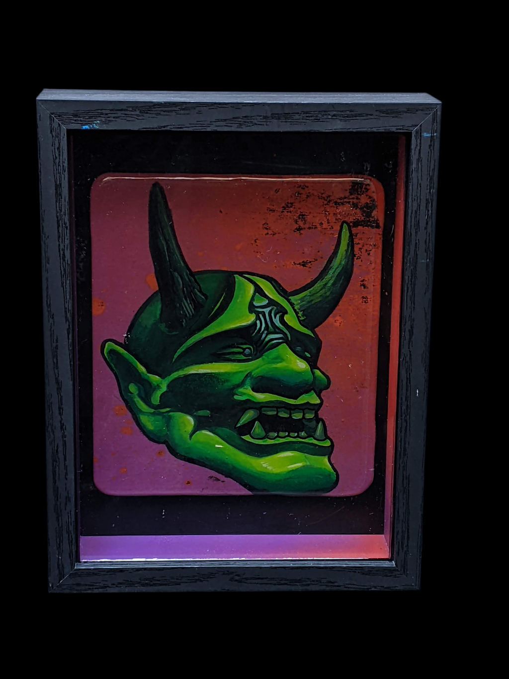 Green hannya mask design on a colorful background with a black frame.