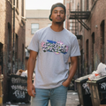 Man standing in an alleyway with graffiti on walls