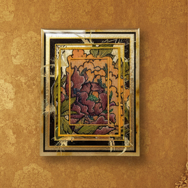 Decorative wall art with floral design and gold frame on a textured brown wall