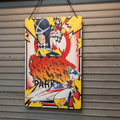Colorful poster with a character in a helmet and vehicle on a wooden surface