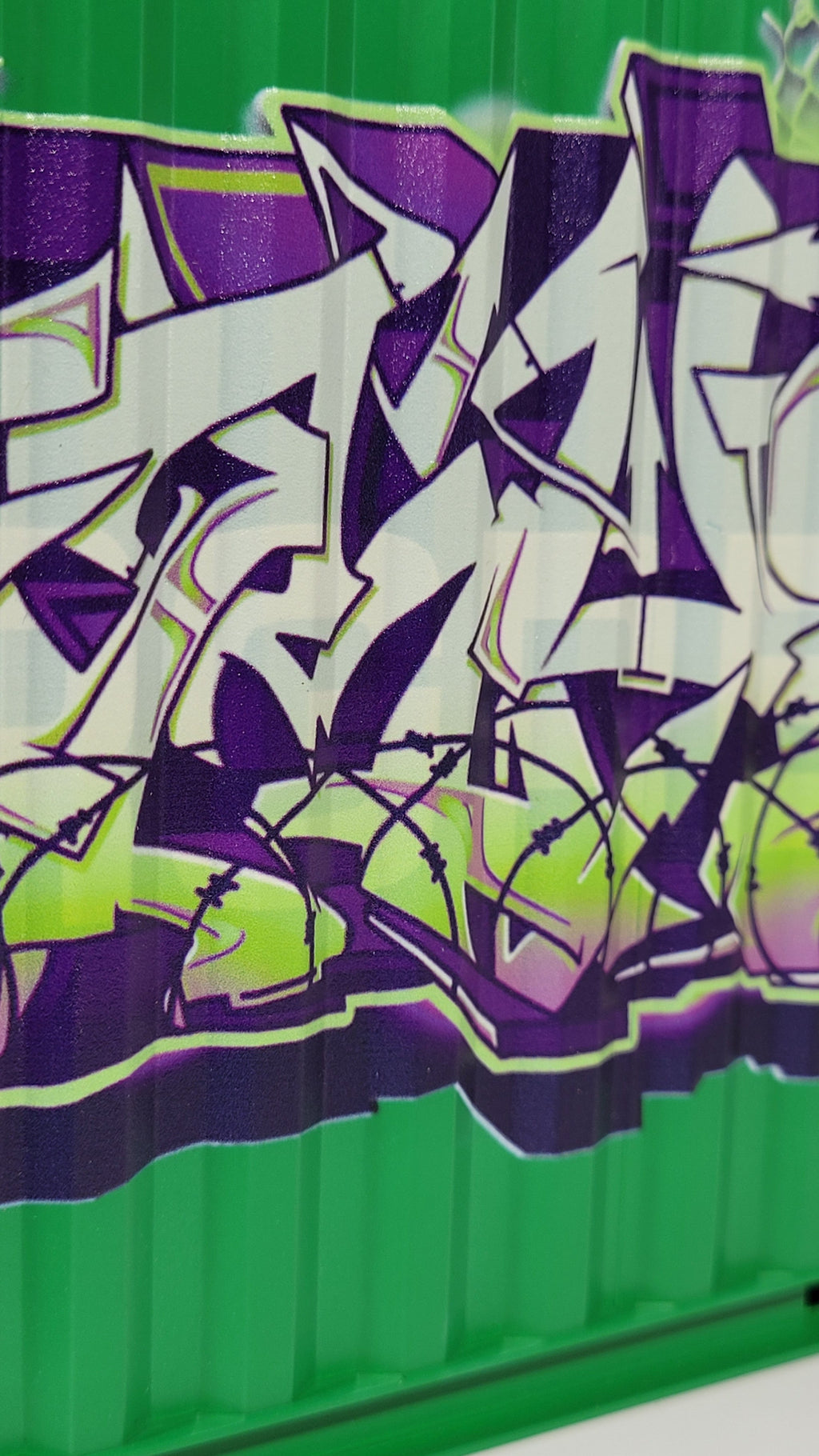 Graffiti art on a green surface with purple and white design
